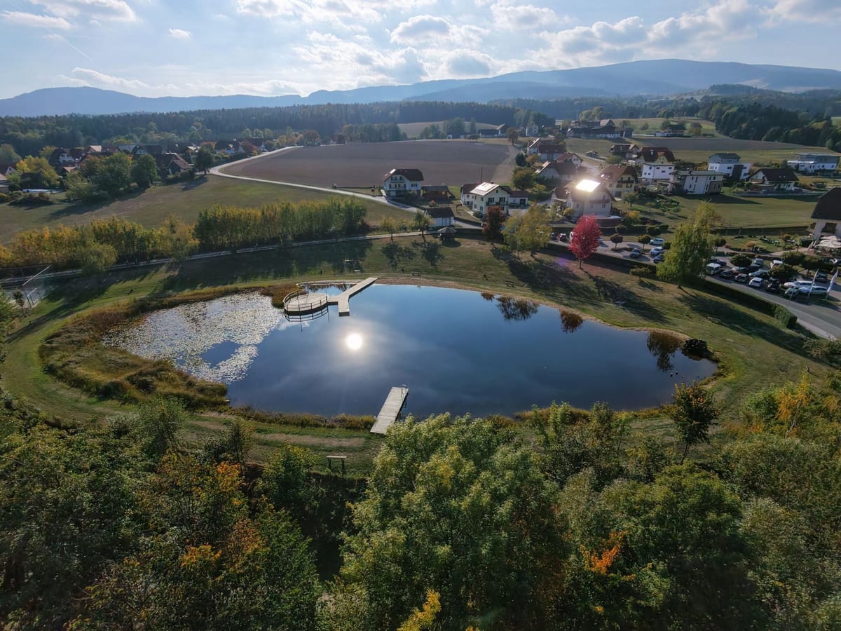 Vista aèria amb dron d’un llac amb embarcadors i un poble al fons